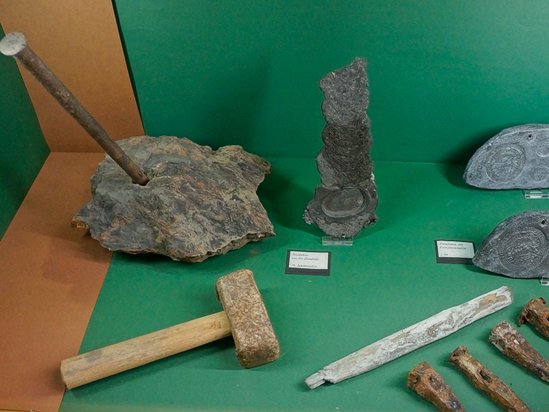 Коллекция горняцких инструментов и товарных оловянных слитков.